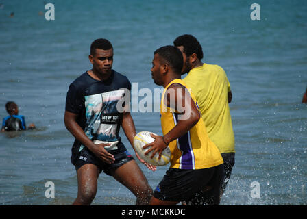 Gli uomini delle Fiji giocando a rugby su Palm Beach, Pacific Harbour, Fiji. Foto Stock