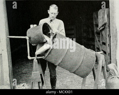 . Fig. 46.-OLIO miscelatore a tamburo, per il trattamento di sementi di cereali con carbonato di rame e altre polveri. (Fotografia fornita dall'autore.) sufficientemente fine da passare attraverso un 200 mesh, ma polvere abbastanza fine a passare attraverso un 300-mesh è migliore. Una miscelazione meccanica la macchina deve essere utilizzata per la vettura di rame- bonate, poiché ogni kernel devono essere accuratamente rivestito. Il metodo di pala di miscelazione non è abbastanza efficiente per questa polvere. Un tamburo di petrolio, un trattamento commerciale macchina o una betoniera può essere utilizzato. Trattamenti di formaldeide.-formaldeide, un gas di dis- infectant, è stata utilizzata sin dal 1897 per semi-borne d Foto Stock