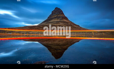 Kirkjufell montagne e riflessione con car light, Islanda. Foto Stock