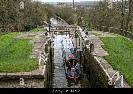 Una barca che si abbassa verso il basso l'aumento di cinque serrature su Leeds e Liverpool Canal, Bingley, vicino a Bradford, West Yorkshire, Inghilterra. Foto Stock