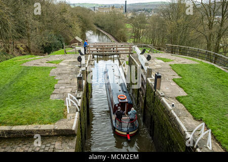 Una barca che si abbassa verso il basso l'aumento di cinque serrature su Leeds e Liverpool Canal, Bingley, vicino a Bradford, West Yorkshire, Inghilterra. Foto Stock