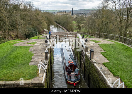 Una barca che si abbassa verso il basso l'aumento di cinque serrature su Leeds e Liverpool Canal, Bingley, vicino a Bradford, West Yorkshire, Inghilterra. Foto Stock