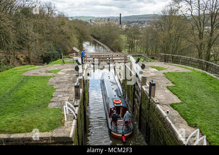 Una barca che si abbassa verso il basso l'aumento di cinque serrature su Leeds e Liverpool Canal, Bingley, vicino a Bradford, West Yorkshire, Inghilterra. Foto Stock