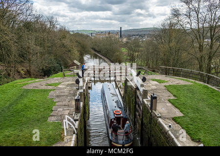 Una barca che si abbassa verso il basso l'aumento di cinque serrature su Leeds e Liverpool Canal, Bingley, vicino a Bradford, West Yorkshire, Inghilterra. Foto Stock