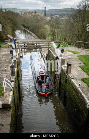 Una barca che si abbassa verso il basso l'aumento di cinque serrature su Leeds e Liverpool Canal, Bingley, vicino a Bradford, West Yorkshire, Inghilterra. Foto Stock