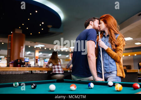 Bella giovane baciare in bar del biliardo Foto Stock