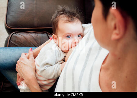 Neonato ragazza è alla ricerca di sua madre mentre ella breastfeeds lei. Foto Stock