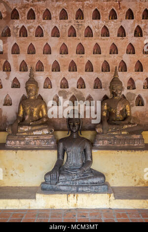 Vista frontale di tre vecchi e di età compresa tra statue di Buddha a Wat Si Saket (Sisaket) tempio della clausura in Vientiane, Laos. Foto Stock