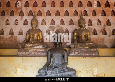 Vista frontale di tre vecchi e di età compresa tra statue di Buddha a Wat Si Saket (Sisaket) tempio della clausura in Vientiane, Laos. Foto Stock