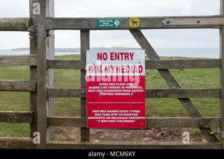 Ministero della difesa del cartello sul cancello di legno in ingresso al poligono di tiro a penalmente, Pembrokeshire, Galles dicendo nessuna voce quando le bandiere rosse sono battenti Foto Stock