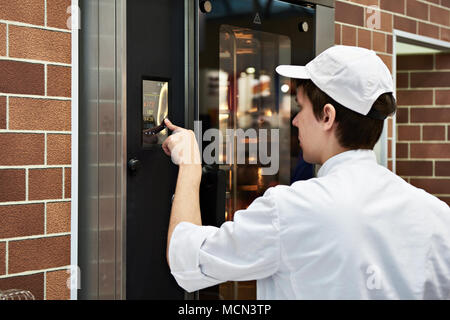 Baker nei pressi di un forno per il pane Foto Stock