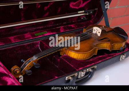 Violino e archetto in rosso scuro caso. Close up Foto Stock