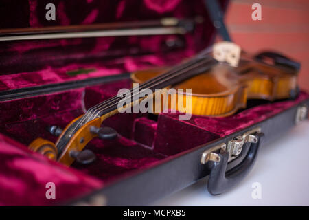 Violino e archetto in rosso scuro caso. Close up Foto Stock