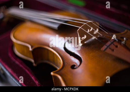 Violino e archetto in rosso scuro caso. Close up Foto Stock