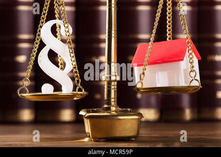 Close-up di paragrafo simbolo e modello di casa su Golden giustizia scala Foto Stock
