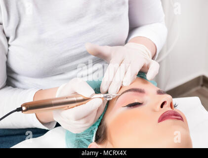 Cosmetologo applicare trucco permanente sulle sopracciglia in studio di bellezza. Sopracciglia tatuaggio Foto Stock