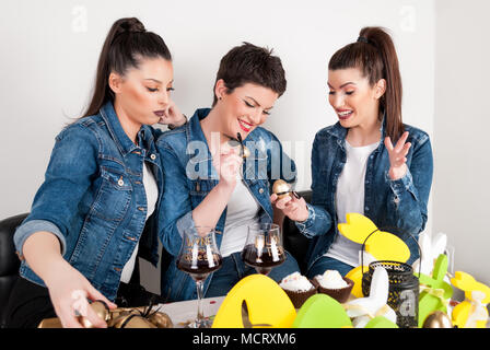 Felice ragazze celebrare la pasqua e per le vacanze giocando con uova di vernice su decorare scrivania Foto Stock