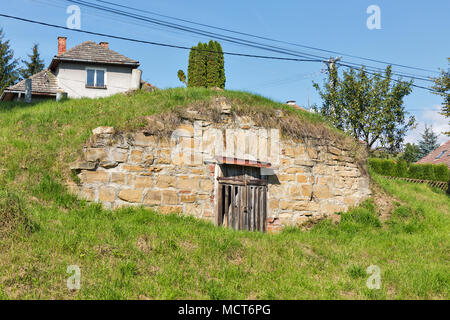 Strada rurale con tipici cottages in una riga, blu cielo chiaro e colline in background Foto Stock