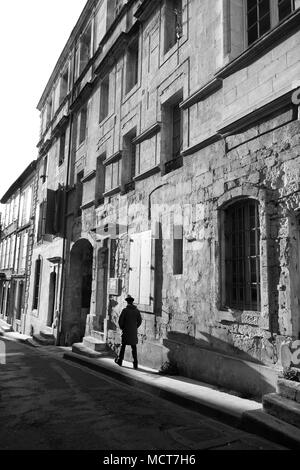 Serata di lunghe ombre proiettate da uomo francese indossando berry hat a Arles Francia Foto Stock