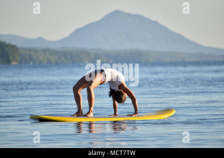 Yoga in stand up paddle board Foto Stock