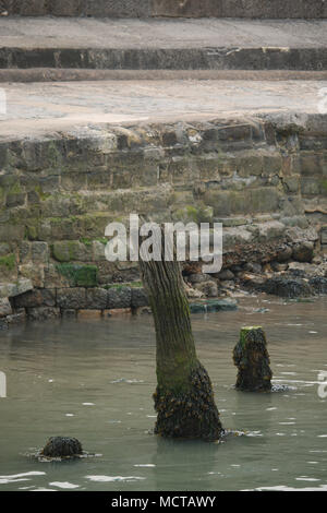 Un set di tre storici posti in piedi in un porto. I resti di un pontile, wharf o punto di ormeggio. Foto Stock