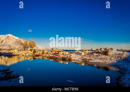 Henningsvaer, Norvegia - 09 Aprile 2018: bella vista sopra di edifici in legno con enormi mountaing dietro in Henningsvaer in Isole Lofoten Foto Stock