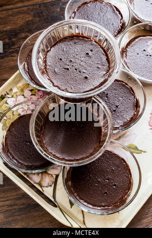 Cioccolato artigianale budini in bicchieri di vetro su una superficie di legno Foto Stock