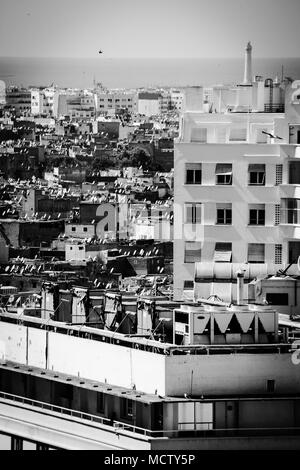 Vecchia immagine in bianco e nero di antenne paraboliche per la ricezione satellitare su un tetto di un edificio alto in Casablanca, Marocco Foto Stock