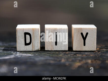 Parola DIY sui blocchi di legno con sfondo sfocato Foto Stock