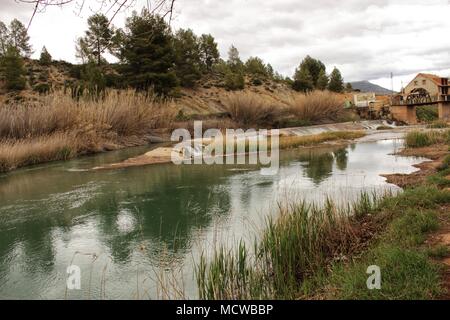 Fiume Cabriel sulla sua strada attraverso Casas Del Rio village, Albacete, Spagna. Paesaggio tra campi di canna da zucchero e le montagne. Foto Stock