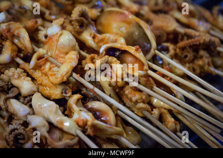 Dettaglio di alcuni calamari spiedini in un cibo di strada in stallo il mercato del weekend, Phuket, Tailandia Foto Stock