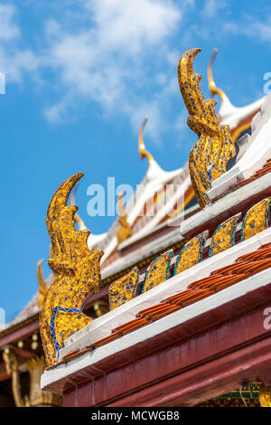 Dettaglio dei tradizionali ornamenti dorati su un tetto al Wat Phra Kaew Palace, anche noto come il Tempio del Buddha di Smeraldo. Bangkok, Tailandia. Foto Stock