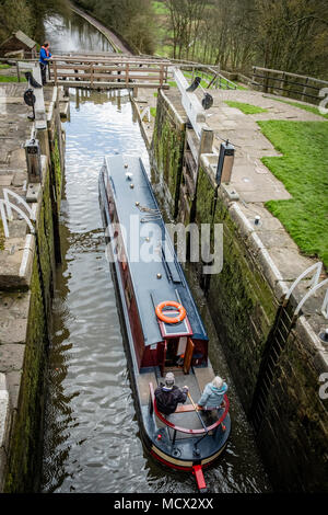 Una barca che si abbassa verso il basso l'aumento di cinque serrature su Leeds e Liverpool Canal, Bingley, vicino a Bradford, West Yorkshire, Inghilterra. Foto Stock