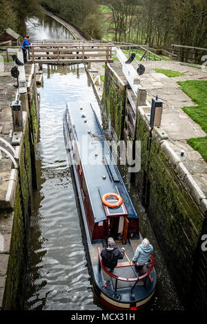 Una barca che si abbassa verso il basso l'aumento di cinque serrature su Leeds e Liverpool Canal, Bingley, vicino a Bradford, West Yorkshire, Inghilterra. Foto Stock