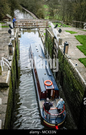 Una barca che si abbassa verso il basso l'aumento di cinque serrature su Leeds e Liverpool Canal, Bingley, vicino a Bradford, West Yorkshire, Inghilterra. Foto Stock