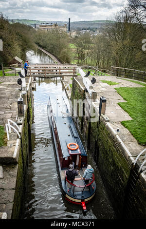 Una barca che si abbassa verso il basso l'aumento di cinque serrature su Leeds e Liverpool Canal, Bingley, vicino a Bradford, West Yorkshire, Inghilterra. Foto Stock