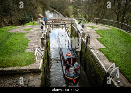 Una barca che si abbassa verso il basso l'aumento di cinque serrature su Leeds e Liverpool Canal, Bingley, vicino a Bradford, West Yorkshire, Inghilterra. Foto Stock