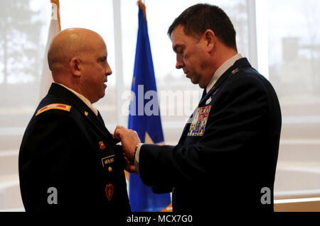 Hanscom Air Force Base, messa. -- Il Brig. Gen. Mark A. Merlino la neo nominato assistente Aiutante Generale del Massachusetts National Guard, è segnato dal magg. Gen. Gary Keefe, l aiutante generale del Massachusetts Guardia nazionale durante il BG Merlino la cerimonia di promozione il 4 marzo 2018. (US Army Foto di Sgt. 1. Classe Laura Berry) Foto Stock