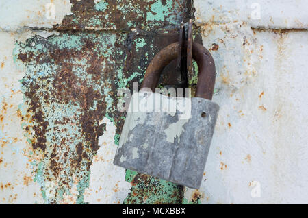 Vecchio lucchetto arrugginito appesi grungy porta di metallo. Close up foto con messa a fuoco selettiva Foto Stock