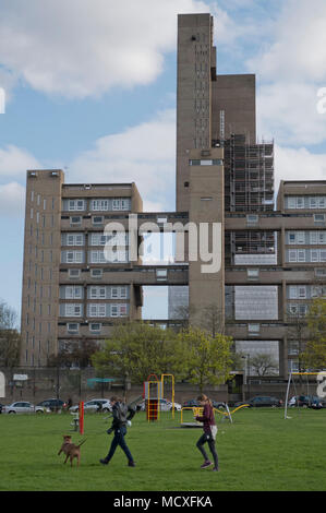 Paesi vicini a piedi il loro cane con una vista del 26 piani torre Balfron autorità locale edificio residenziale costruito in fase di ristrutturazione in architectu Foto Stock