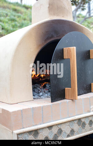 Forno a pizza fatta di mattoni e cemento e piastrelle in pronto per la  cottura della pizza con legna da ardere Foto stock - Alamy