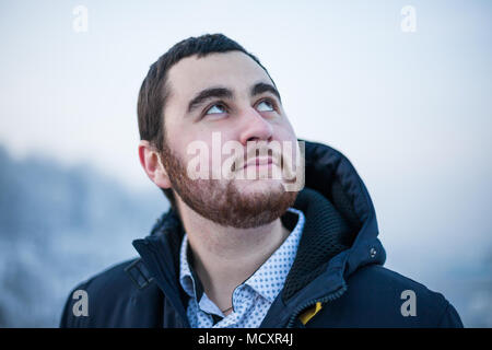 Ritratto di un giovane sognando uomo felice guardando il cielo blu Foto Stock