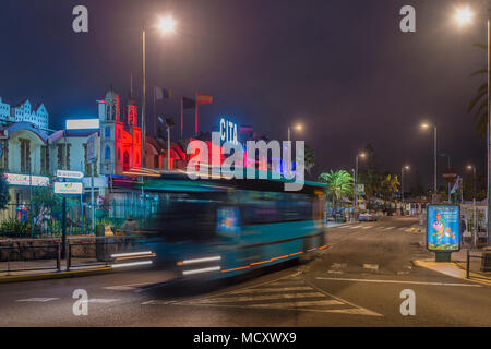 Vista notturna, autobus con sentiero di luce nella parte anteriore del centro commerciale, Playa del Ingles, San Bartolomé de Tirajana, Gran Canaria Foto Stock