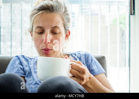 Donna che mantiene tazza da caffè Foto Stock