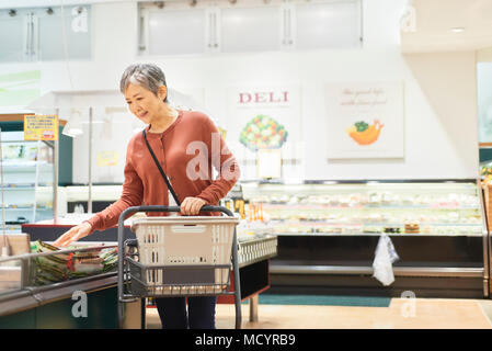 Senior donna shopping nel supermercato Foto Stock