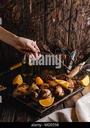 Ritagliato colpo di donna versando miele sul gustose grigliate di carne Foto Stock