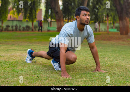 Giovane ragazzo facendo esercizi yoga in un parco Foto Stock