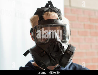 Dustin Ylitalo, parco dei cervi centro scuola studente, cerca su un M50 maschera a gas ad un stand informativo durante la Eastern Washington Regional Science and Engineering Fair a Spokane Washington State University campus, Washington, 15 marzo 2018. Membri del team di Fairchild ha presenziato la fiera per fornire gli studenti in visita con informazioni sulla scienza, la tecnologia, ingegneria e matematica i campi correlati che U.S. Air Force offre. Foto Stock