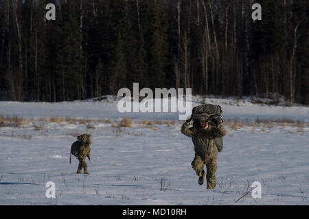 Paracadutisti assegnato alla quarta brigata di fanteria combattere Team (airborne), XXV divisione di fanteria, U.S. Esercito Alaska, attraversare la coperta di neve terreno a Malemute Drop Zone, Base comune Elmendorf-Richardson, Alaska, Marzo 22, 2018. I soldati del 4/25 appartengono al solo American airborne brigade nel Pacifico e sono addestrati per eseguire le manovre di volo in condizioni di freddo intenso/ambienti ad altitudini elevate a sostegno di combattimento, di formazione e di aiuto in caso di catastrofe. Foto Stock