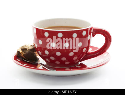 Grande tazza di tè in un bicchiere di rosso con puntini bianchi Foto Stock